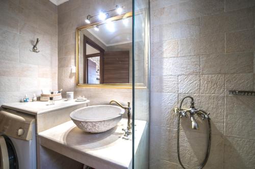 a bathroom with a bowl sink and a shower at Arhontariki Luxury Apartment in Panormos Rethymno