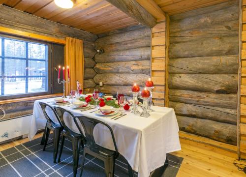 comedor con mesa en una habitación con paredes de madera en Kuukkeli Log Houses Porakka Inn, en Saariselkä