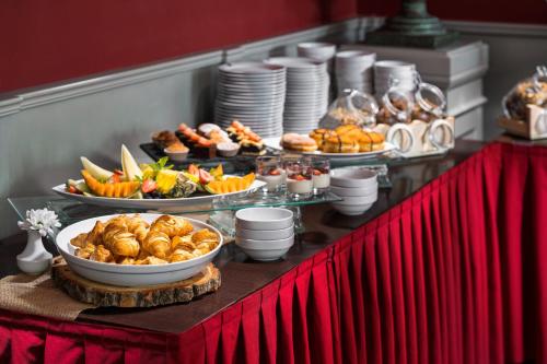 a buffet with many plates of food on a table at Clarion Grandhotel Zlaty Lev in Liberec