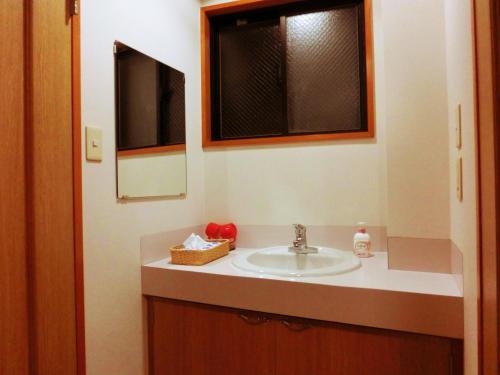 y baño con lavabo y espejo. en Oyado Uemasa, en Nozawa Onsen