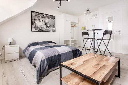 une chambre avec un lit, une table et des chaises dans l'établissement Studio New York, à Tourcoing