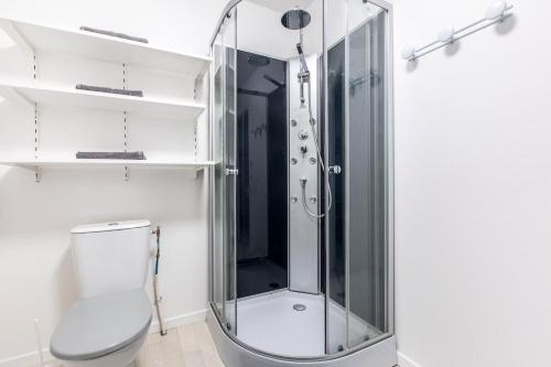 La salle de bains est pourvue d'une douche en verre et de toilettes. dans l'établissement Studio New York, à Tourcoing