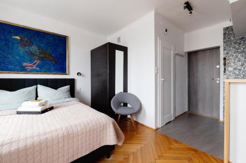 華沙的住宿－Kwiatowa Warsaw Apartment，卧室配有一张床,墙上挂有绘画作品