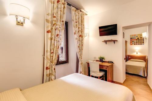a bedroom with a bed and a desk and a table at Hotel Gea Di Vulcano in Rome