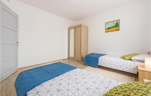 a bedroom with two beds and a blue blanket at Cozy Home In Vodnjan With Wifi in Vodnjan