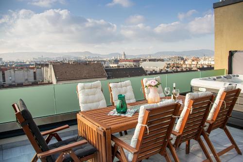 einen Tisch und Stühle auf einem Balkon mit Aussicht in der Unterkunft BRAND NEW LOFT LUXURY PENTHOUSE WITH JACUZZI #Centropolitan in Budapest