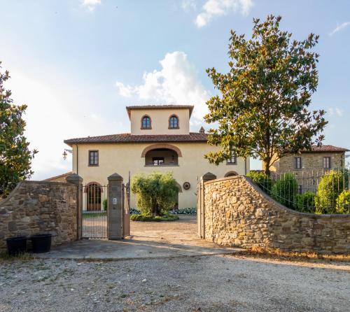 a house with a stone wall and a gate at Leopoldina L'Orto in Arezzo