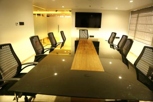 a conference room with a long table and chairs at Crystal Suites in Badagara
