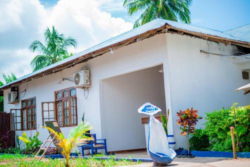 a small white house with a garage at Ondo House in Nungwi