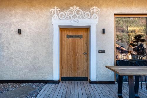 a wooden door in a building with a wooden table at Spornberg Mountain Living Westberg in Soprabolzano