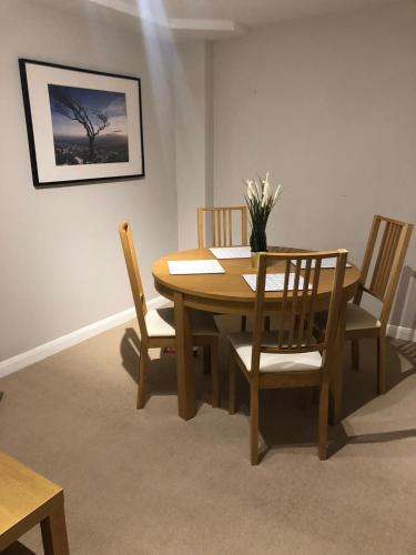 a dining room with a wooden table and chairs at Cute flat in Whitechapel in London