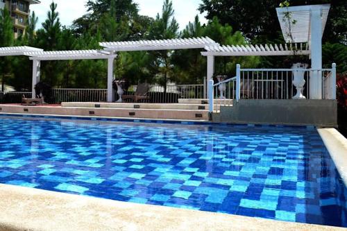 uma grande piscina com azulejos azuis em 2BR Condo Unit with Washer, INET, Desk Space, ground floor em Davao