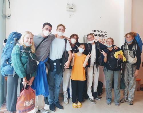 a group of people wearing masks posing for a picture at City Hostel Da Nang in Da Nang