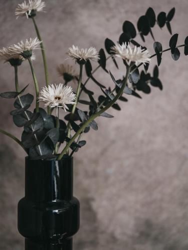 a black vase with white flowers in it at The Crystal VAYA Unique in Obergurgl