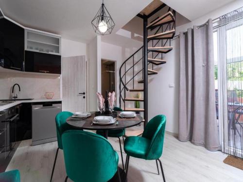 a kitchen and dining room with a table and green chairs at Apartment Dionis Domus in Vela Luka