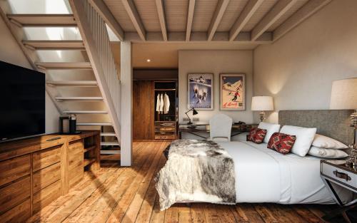 a bedroom with a bed and a tv and stairs at Hotel Maribel in Sierra Nevada