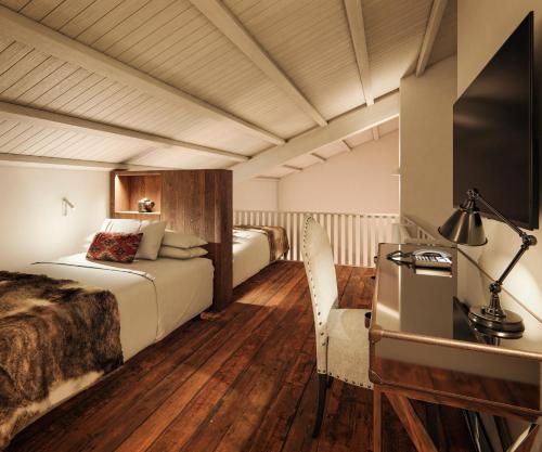 a hotel room with two beds and a television at Hotel Maribel in Sierra Nevada