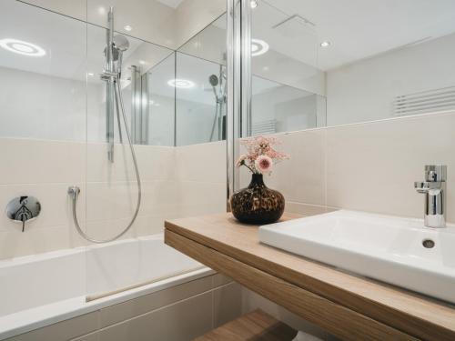 a bathroom with a shower and a sink and a bathtub at The Crystal VAYA Unique in Obergurgl