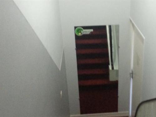 een trap in een witte kamer met een trap bij Hôtel Le Hussard in Alençon