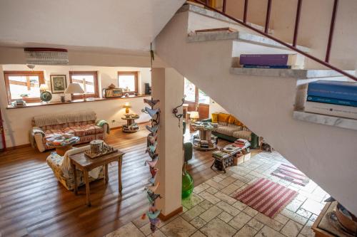 una vista aérea de una sala de estar con una escalera en Maison Le Champ B&B Questa casa non è un albergo, en La Salle