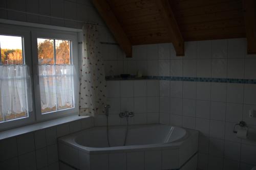 a bath tub in a bathroom with a window at Haus Maria in Ahlbeck