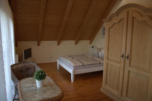 a bedroom with a bed and a table with a chair at Haus Maria in Ahlbeck