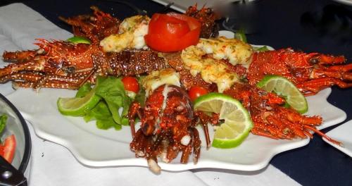 a plate of food with shrimp and vegetables on a table at Las Puertas del Paraíso in Río San Juan