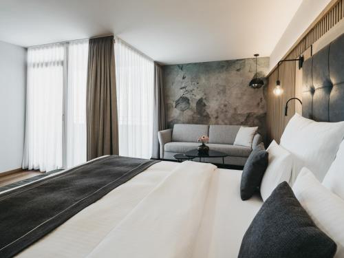 a hotel room with a large bed and a couch at The Crystal VAYA Unique in Obergurgl