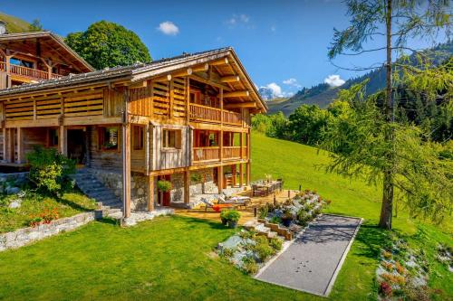 una grande casa in legno con un giardino di fronte di Chalet Argali - OVO Network a Le Grand-Bornand