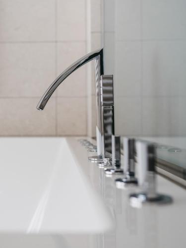a bathroom sink with a row of faucets at The Crystal VAYA Unique in Obergurgl