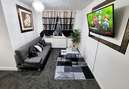 sala de estar con sofá y TV de pantalla plana en *5SM* Setup for your most relaxed & amazing stay + Free Parking + Free Fast WiFi * en Morley