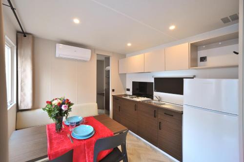 a kitchen with a table and a white refrigerator at Camping Rialto Village in Campalto