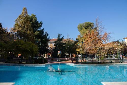 una gran piscina en un parque con árboles en Pascoli Home a Cattolica Centro Mare by Yohome en Cattolica