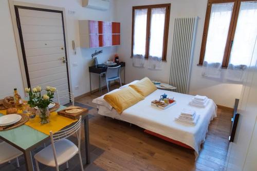 a small room with a bed and a table with a tableablish at Pascoli Home a Cattolica Centro Mare by Yohome in Cattolica