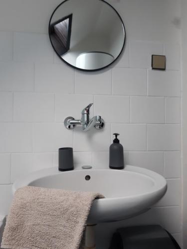 y baño con lavabo blanco y espejo. en Penzion Oráč, en Velemín