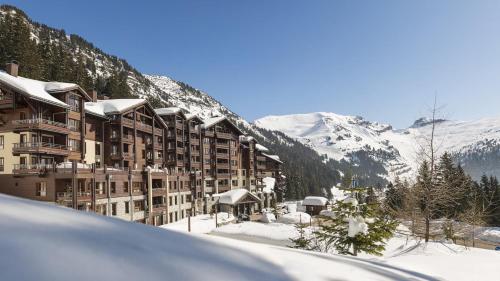 un hôtel dans la neige avec des montagnes enneigées dans l'établissement Appartement Premium à Flaine, altitude 1740 m, 8 à 10 personnes, au pied des pistes, piscine, jacuzzi, sauna, hammam et salle de sport, à Flaine