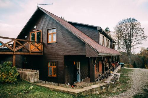 a black house with a gambrel roof at Weavers' Guest House Kalndaki in Milzkalne
