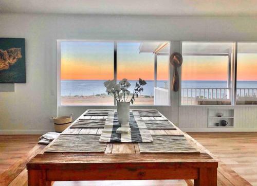 a table in a room with a view of the beach at The Landing Aldinga Beach Front Private Pool in Aldinga Beach