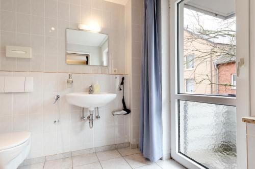a bathroom with a sink and a toilet and a window at Hotel Helgolandia in Helgoland