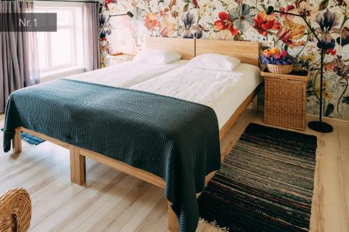 a bedroom with a bed with a green blanket on it at Kalndaķi in Milzkalne