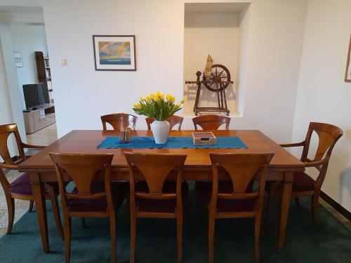 a wooden table with chairs and a vase of flowers on it at Place of Peace in Aachen