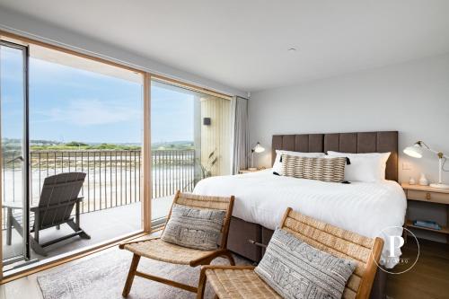 a bedroom with a bed and a balcony at Primero Apartments - Hayle Villas in Hayle