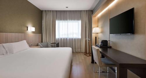 a hotel room with a bed and a desk at NH Madrid Ribera del Manzanares in Madrid