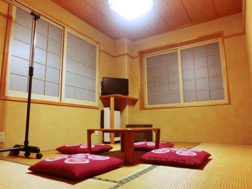 a room with four red pillows in a room with windows at Oyado Uemasa in Nozawa Onsen