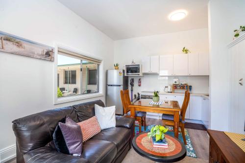 uma sala de estar com um sofá de couro e uma mesa em One Bedroom Apartment on Summer/ No.2 near CBD em Orange