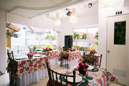 uma sala de jantar com mesas com toalhas vermelhas e brancas em Grand Peninsula Suites em Balanga