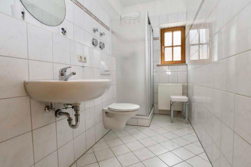 een witte badkamer met een wastafel en een toilet bij Gästehaus Wechs in Bad Hindelang