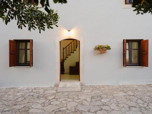 een wit huis met een deur en een trap bij Villa Nikolaos in Elefterna