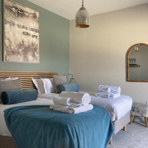 a room with two beds with towels on them at Blue Iris Cottage, Ashlin Farm Barns in Lincoln