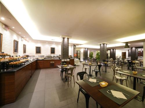 a restaurant with tables and chairs in a room at La Meridiana Bleisure Hotel in Perugia